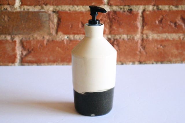 Cylindrical bottle, slightly wider at the shoulder than the base. Black clay base comes about a third of the way up the main body, then transitions with a hard (but slightly swirled) edge to white clay at the top.