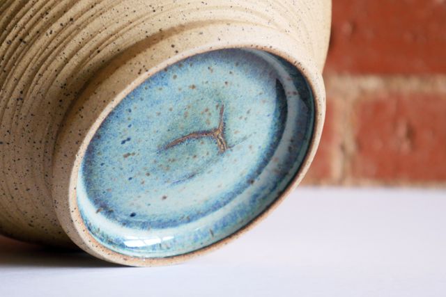 Hidden inside the foot ring of one bowl, there is a triangular crack that's been filled and glazed over - but is still visible.
