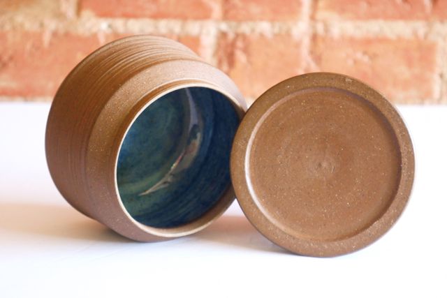 The lid is also angular, with the top slightly inset compared to the outer quarter inch. The rim is delicate, and inside the jar is full of color.
