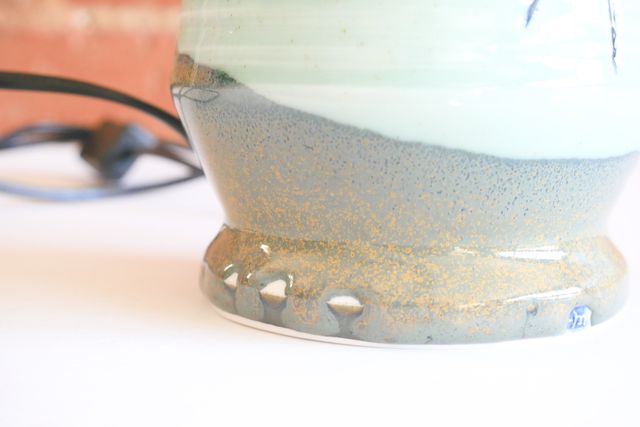 Close up on the side of the foot ring, where the glaze has separated slightly creating almost reverse-drips of small bare patches.
