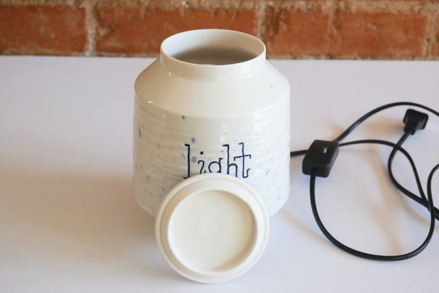 The lid is a thin slab, with a short locating flange that protrudes on the bottom. The power cable is black with a rocker switch.
