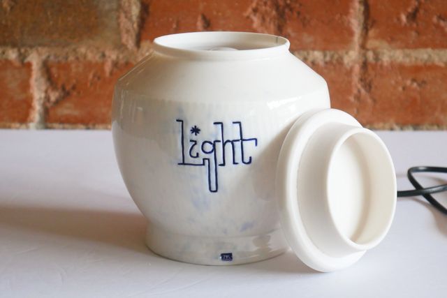 With the lid off, the bulb comes almost to the rim. The rim is leaning against the side, and reaches most of the way to the angled shoulder of the jar. The lid is slab-like from the side, but has a locating flange inset.
