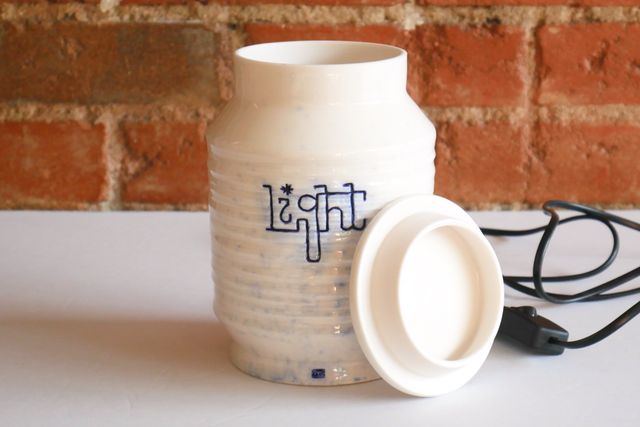 The lid is off and leaning against the piece with a locating flange that angles in slightly.
