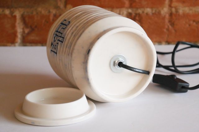 From below, the foot is hollowed out with an inset base, where nut and washer hold the mount in place. A black cable emerges from under the jar, and through a small hole out the back of the foot ring.
