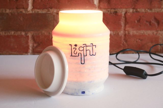 The light on, with the lid off. Not only a glow through the porcelain, but also light pouring from the opening.
