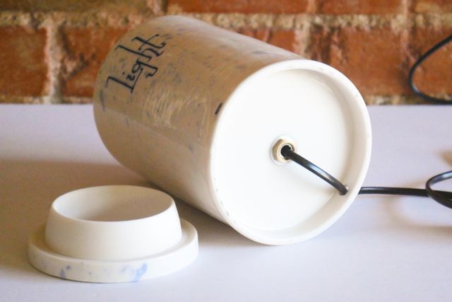 A black lamp cord with a rocker switch enters the base from the back, and continues up into the jar where the light socket is mounted.
