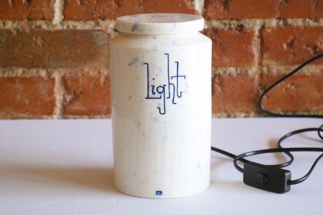 With the light off, the jar is white with subtle blue splashes and a blue stamp at the base.
