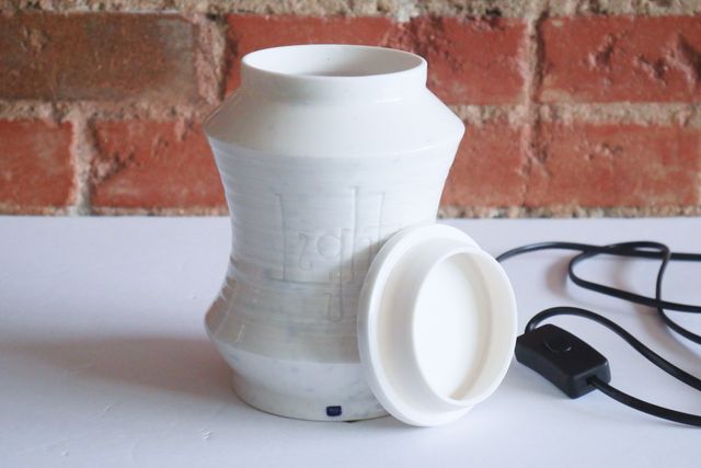 The shape is nearly symmetrical top to bottom, upright at each end, then angled out - but the middle curves back in concave, like an apple core or hourglass. The lid has a slab-like edge with a slight angle, and a locating flange inside to help it set into place.
