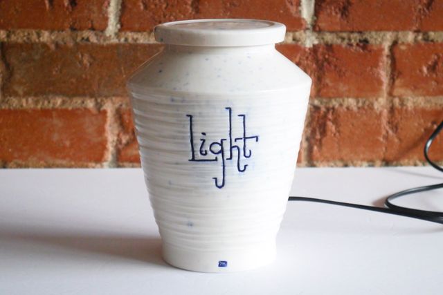 With the light off, the jar is white with subtle blue splashes and a blue stamp at the base.