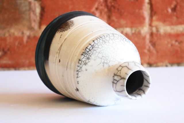 The inside is also black, with crackle patterns forming near the rim, and continuing ot the outside - down the neck and onto the shoulder.