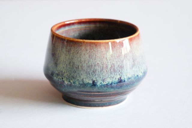 An espresso or sake cup with glazed nebula blues and whites and deep space coffee browns flowing together.
