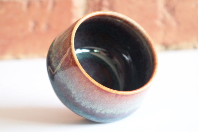 The rim of each is a shiny red-brown cream dripping into blues and then deeper coffee tones.
