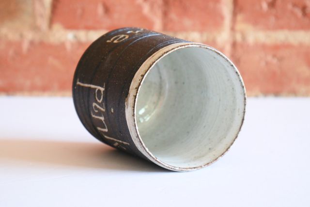 The inside and rim are glazed white, with occasional specks of clay showing through.
